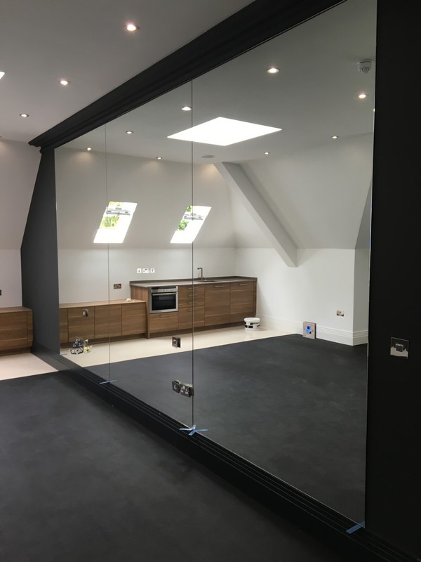 Frameless glass partition in loft conversion by Merton glaziers