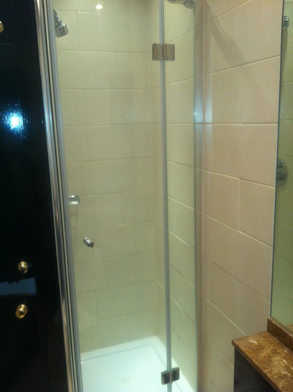 Frameless glass shower enclosure with chrome fittings in Merton