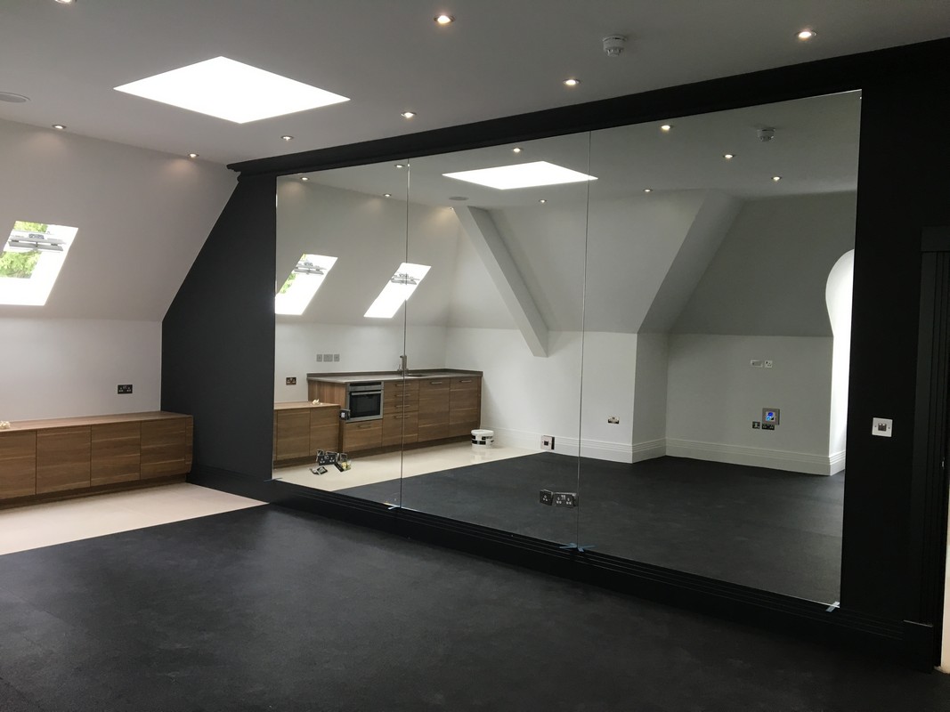 Frameless glass wall dividing loft conversion in Merton